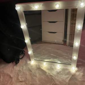 En jättefin spegel med lampor. Sladd medföljer men kan även användas med batterier. Kan stå upp men finns även hål till upphängning😊