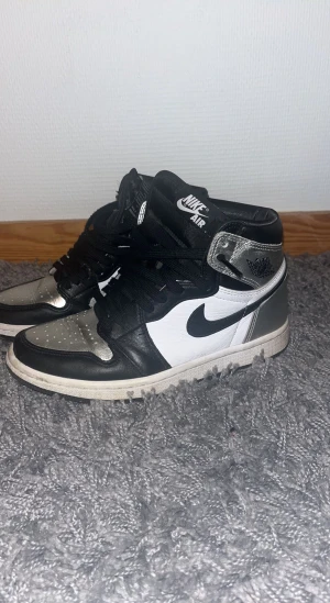 Air Jordan 1 Retro High Silver Toe - Storlek på skorna är 36.5. Skorna är använda i gott skick men tyvärr lite creasade. Nypris- skorna köptes för 3200kr och säljer för 1800kr Kan diskutera pris om det skulle vara så.  Skorna är inte helt tvättade innan fotot togs. Välkommen med frågor :) 
