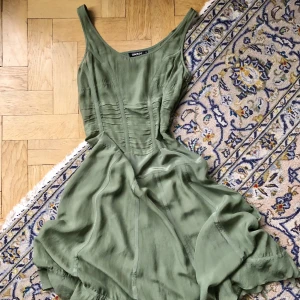 Klänning, silke, DKNY - 100% silkesklänning från DKNY! Helt felfri i en vacker mossgrön färg. I strl 4 = en liten S! Så himla vacker men kräver en underklänning eller liknande då den till större delen är genomskinlig. Bara att höra av er om ni vill ha fler bilder! Eller prova ✨