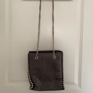 Väska - Väskan är i hyffsat bra skick, den enda synliga är lite rostfärg på bandet