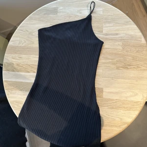 Tight one shoulder black dress - Tight svart klänning.  Storleken är XS och ganska stretchig.  Längden är strax över knäna.  Nytt med lapparna kvar.  köpt för:129kr ♥️