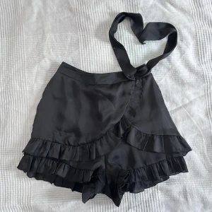 Söt omlottkjol - Så sjukt söt omlottkjol med volanger  i skönt material. Perfekt inför sommaren. Banden går att knyta i en rosett om så önskas. Shorts under så man inte råkar flasha lol. Aldrig använd och säljes pga för liten storlek, superfint skick!!