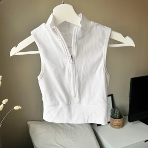 Croppad vit topp strl xs  - Snygg vit croppad top med half zip, aldrig använd. Strl xs, 50kr