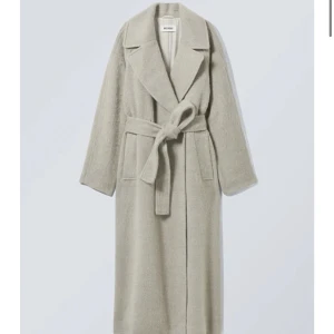 Weekday Kappa  - Säljer denna kappan från weekday. Helt oanvänd då den är lite för lång för mig. Jätte mjuk och skön och super fin. Den är beige med en liten grå ton (ser väldigt grå ut på den andra bilden) Den är i storlek L men passar XS-S också. Köpte den för 1400kr 