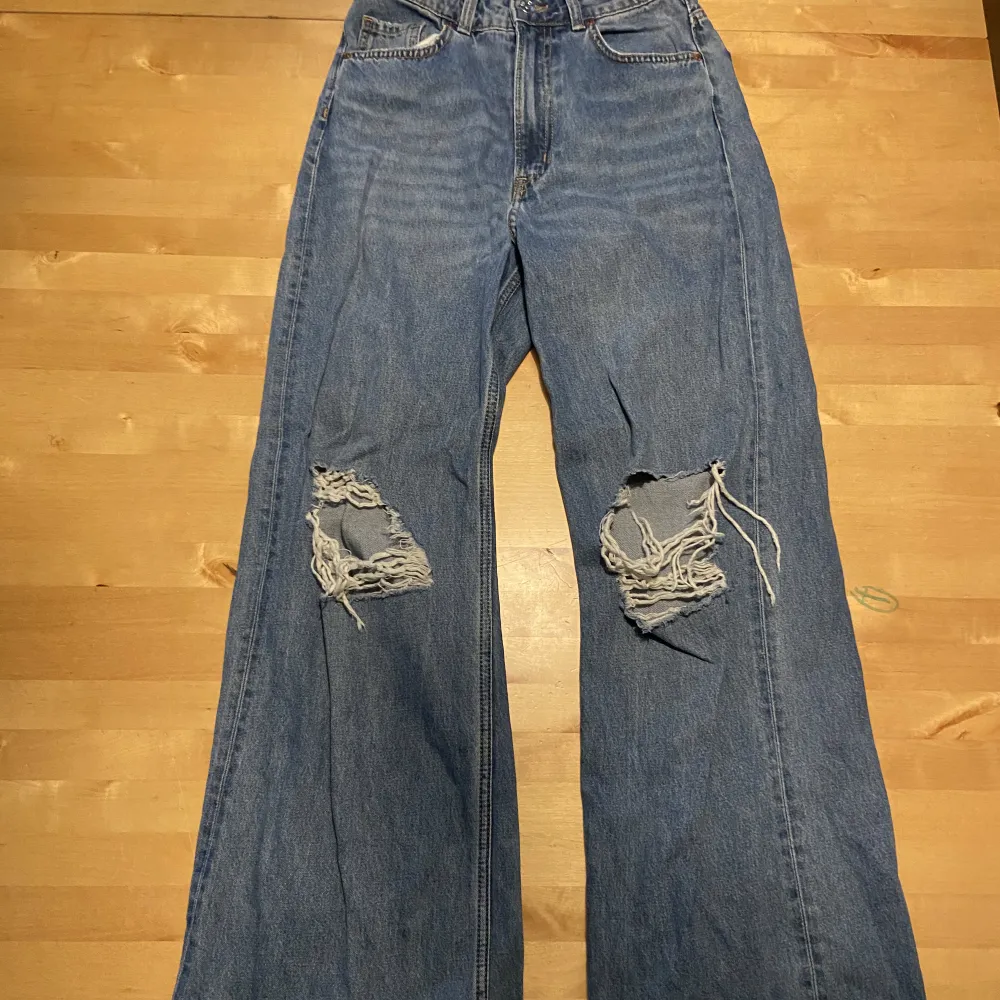 Högmidjade blåa jeans med hål i. Helt oanvända . Jeans & Byxor.