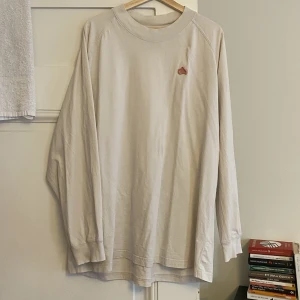 Acne vit longsleeve, strl M - Liggandes hemma, behöver nytt hem. Longsleeve från deras blå konst ”gum” kollektion. Såg nu att den har ett litet smutsstreck fram som kommit från varit i en kartong. Annars i bra skick! Oversized som bara den så som acne är. Köpare står för frakt.
