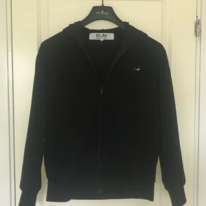 PLAY - Cdg Svart zip hoodie - Svart zip hoodie från cdg. storleken är M men dem storlekarna brukar alltid vara små på Comme des garcons så om ni har L så passar den nog inte.  PRISET GÅR ATT DISKUTERAS