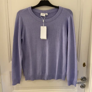 Stickad tröja - Stickad tröja från vila. Köpt i sommras men osäker på om färgen passar mig där av oanvänd me lappar kvar. Färgen är lite lila blå. Köpt för 280kr