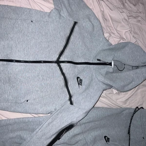 Nike tech fleece tracksuit - Köptes i januari och har bara använts 3 gånger. Tröjan är i XS och byxorna i M.  Byxorna har dock krympts lite i tvätten så skulle säga att de passar bra på er med XS och S. Häng-strigen på insidan sprättes upp i en tvätt & därav sänker jag priset. Går fortfarande att hänga den då stringen inte gått av helt utan det år bara det svarta runtom. Annars inga andra tecken på slitage eller användning, ser ut som helt ny. Fråga gärna om fler bilder ifall intresserad! Köptes för 2350kr 