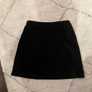 Manchester-kjol - En svart mini-kjol i manchester. 