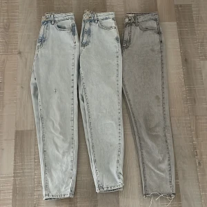 Jeans Gina tricot - Två blåa jeans i storlek 32, ett av paren har lite slitningar. Grå jeans i storlek 34 med avklippt benskaft. Alla är lite vidare modell. 100kr/st eller bud. Köpare står för ev frakt!💗