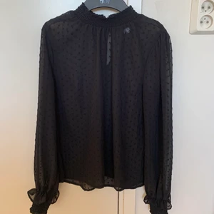 Svart långärmad blus - En långärmad svart blus med hög krage, väldigt söt! Tunnt material med fina inbroderade hjärtan i tyget! För liten för mig