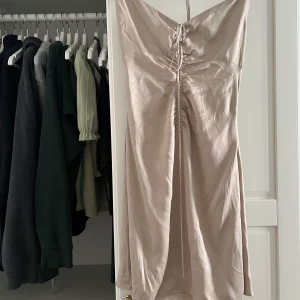 Kort beige klänning - Helt ny, oanvänd beige klänning från Zara med prislapp kvar! Klänningen är i satinmaterial. Köptes i Spanien för 26€ (294kr) plagget säljes dock inte längre på hemsidan🤍 strl M men passar även S💓 