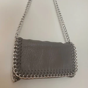 Tiamo väska - Säljer nu min nästan helt nya Tiamo väska! Den är i färgen grå, storlek S. Den är använd men bara några gånger så är därför i helt nyskick! Hör av er vid fler bilder osv. Köparen står för frakt🥰