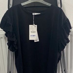 Topp - Topp med voulanger från Zara Den e helt oanvänd o lappen sitter fortfarande kvar, säljer den för att den inte sitter så bra på mig. Den är i storlek S. Tar swish (köparen står för frakt)