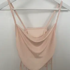 Ljus rosa cowl neck crop-top från SHEIN i storlek S. Den är använd tre gånger utan deffekt. Vardera sida har självknytning, anpassningsbart för storleken. 