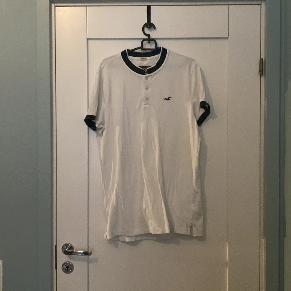 Stor vit t-shirt från Hollister. Har en liten brun fläck nära loggan. Sitter inte tight alls och har används tre gånger. . T-shirts.