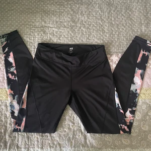 H&M träningsbyxor - Svarta träningsbyxor som är lite färgglada på sidorna.