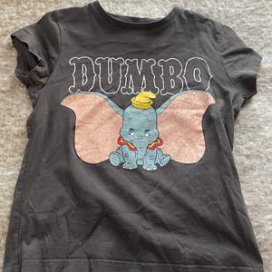 Här är en svart t-shirt med ett Dumbo tryck på tröjan. Den är i storlek 146/152 och passar perfekt till sommaren. Jag säljer den för att jag inte använder den längre, den är använd fåtal gånger.