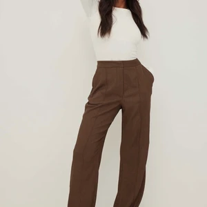Bruna kostymbyxor från Nakd - Säljer dessa fina bruna populära kostymbyxor, har knappt använt dem. Jättebra skit o ser inprincip nya ut. Storlek 36