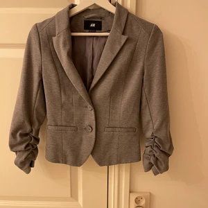 Snygg grå 3/4 ärm kavaj - Enkel och snygg kavaj. Använt ett fåtal gånger som ”jacka”. 3/4 ärm. Alltså ärmarna går inte ända ner till knogarna.