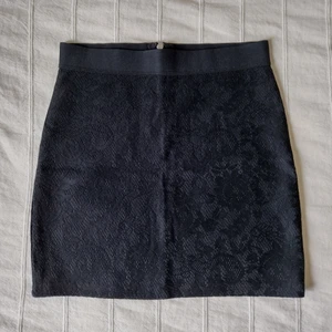 H&M svart kort figursydd kjol med spets - lace skirt - Svart kort figursydd kjol med resår i midjan och dragkedja i bak. Använd en gång och i fint skick.