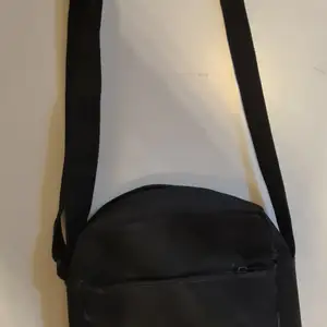 En svart Adidas väska fint skick är nästan inte använd. Det är en yterficka och en innerficka. 