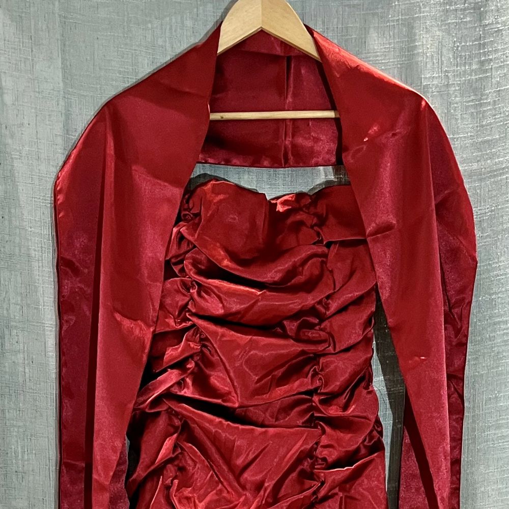 Röd festklänning som går att variera bredden på över bröstet då den har knytning bak (se bild). Medföljer gör också en matchande schal. Har använts vid ett tillfälle på en gala. . Klänningar.