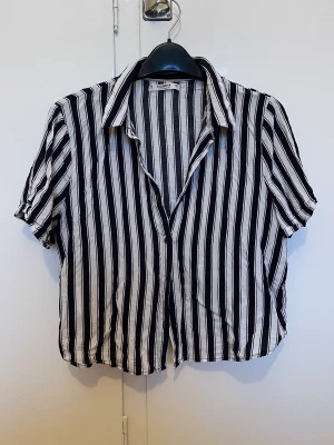 Randig skjorta  - Kort randig skjorta från pull & bear. Använd men i bra skick. På alla varor som kostar 50kr är det ta 3 betala för 2.