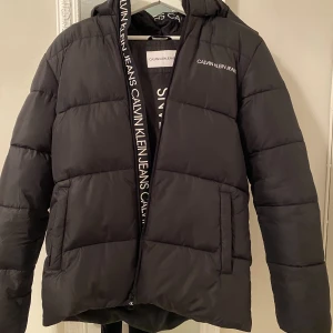 Calvin Klein Jeans Jacka stl 16 - Hej! Säljer nu min Calvin Klein jacka då jag känner att den inte riktigt är något för mig längre, är i superfint skick och knappast använd har dock en liten skråma på insidan(fler bilder vid intresse)Jackan är från KidsBrandStore, nypris 1400