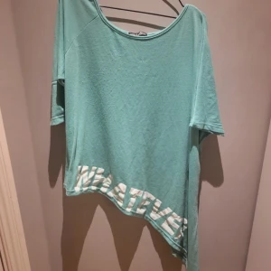Turkos tröja - Köpt i Grekland så den saknar märke och storlek. Passar mig så den är förmodligen i storlek L. Den är klippt diagonalt och det står whatever längst ner. Lite använd. 