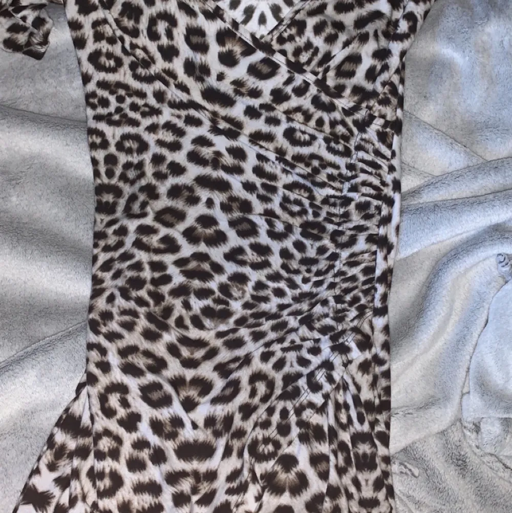 Klänning i leopard men urringning och slits, väldig fin o skönt strachit material. Säljs pga används inte.. Klänningar.