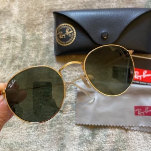 Ray-Ban round metal sunglasses - Nästintill oanvända solglasögon från Ray-Ban i modell round metal i färg green/gold. Putsduk och fodral medföljer.