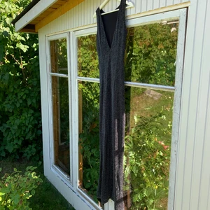 Glittrig klänning - Fin nyårsklänning med V-ringad baksida. Använd vid ett tillfälle och är i nyckick. 