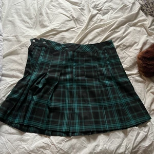 Grön och svart rutig kjol - Mörkgrön och svart rutig kjol från H&M i storlek 40. Helt oanvänd. Om du har några frågor så är det bara att kontakta! :)