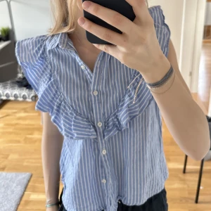 Mango blus! - Fin blå, vit och silver randig blus med volanger från mango! 