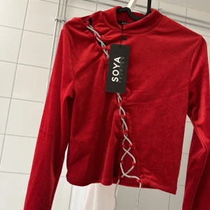 Red velvet crop top - Röd  magtröja med glittriga snören, helt ny och oanvänd, bara provat den. Tagg sitter kvar. Storlek S. Ordinariepris: 170 kr