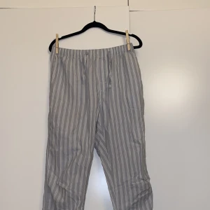 Randiga pyjamasbyxor  - Randiga ljusblåa pyjamasbyxor från HM, storlek S från herr avdelningen så skulle säga det passar som M för dam. Färgen är som på andra bilden. Jätte sköna och tunna men lite för korta för mig som är 175. Säljer även några svartvita rutiga i samma storlek.