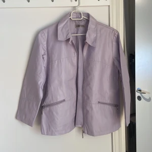 Ljuslila jacka - Har lite spruckna kanter i materialet men inget man lägger märke till
