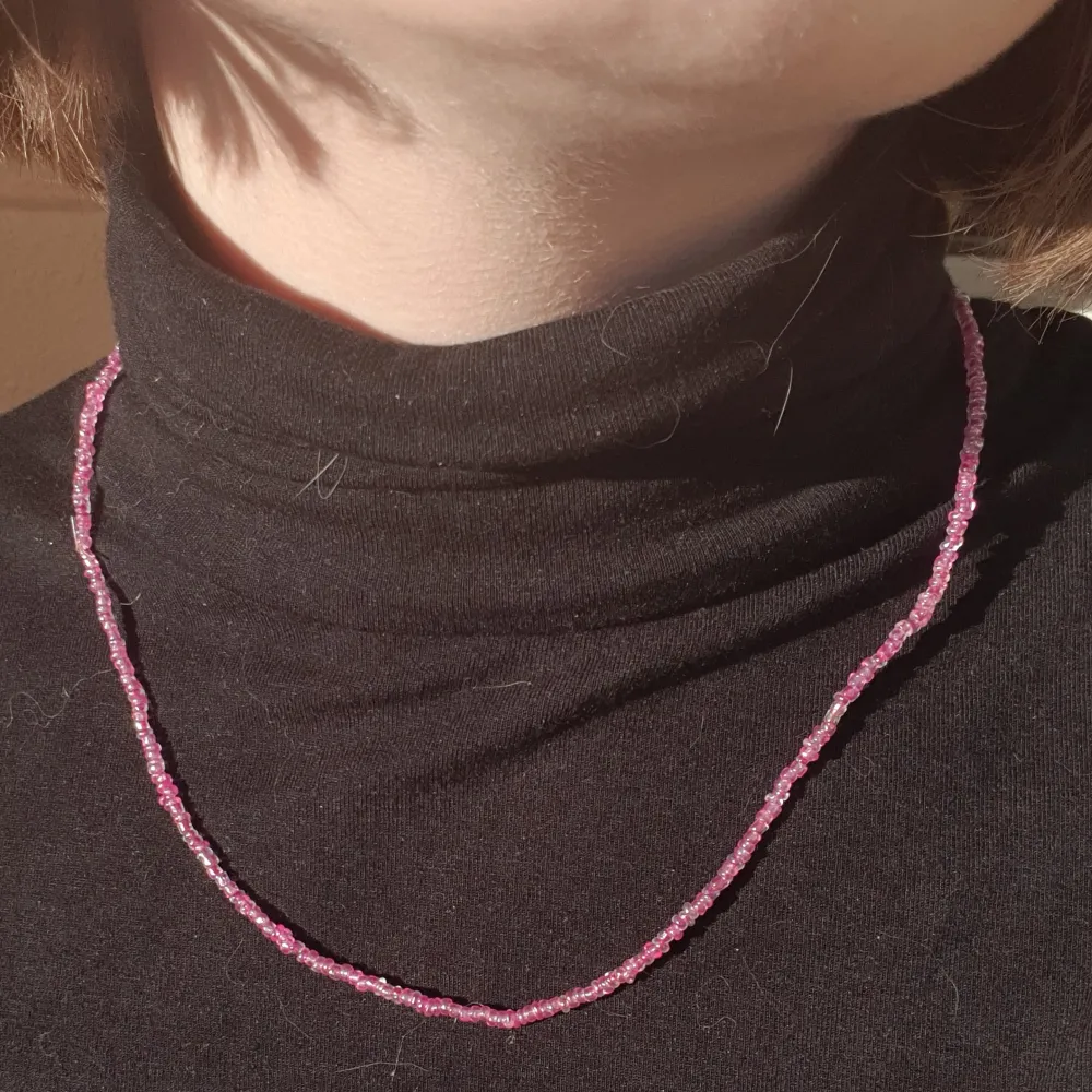 Halsband gjort med rosa glas och plast pärlor med elastisk tråd.. Accessoarer.