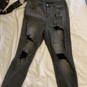 Svarta jeans - Tajta svarta jeans med hål i storlek xl, knappt använda, säljer då dom inte används. Frakt tillkommer