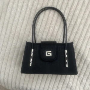 Guees väska - Jätte snygg guees väska med silver detaljer🖤 Vet ej om den är äkta! Köpt på Stockholms stadsmission! Kontakta oss vid frågor eller fler bilder<3