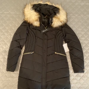 Vinterjacka med pälshuva - Jacka köpt från Bubbleroom i storlek 36/38. Aldrig använd och har fortfarande kvar alla lappar. Huvan har fuskpäls. Pris 450kr (ordinarie 999kr) men priset kan diskuteras!