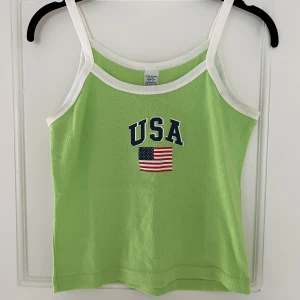 grönt linne - Grönt linne med tryck, köpt second hand. Säljer på grund av den inte kommer till användning. 