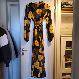 Långklänning - Tunn långklänning köpt på shein. Svart med gula och orangea blommor. Knappt använd, nyskick. 