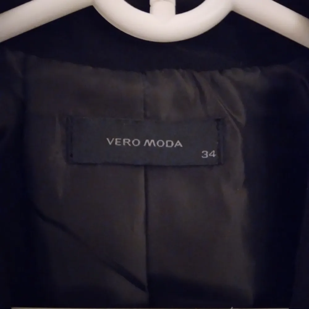 Kort svart kavaj från Vero Moda med 2 fickor.  Strlk: 34 / XS. Material: Polyester + satinfoder. Stängs med knapp. Endast använd 1 gång. Felfri.  FRAKT TILLKOMMER.. Jackor.