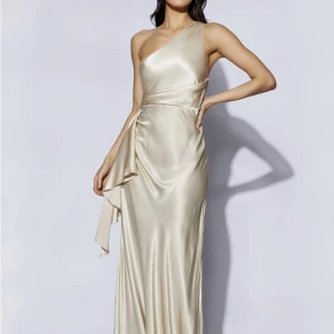 Balklänning  - One shoulder champagne balklänning från meshki. Aldrig använd (nyskick). Storlek S, jag är 170 och den passar mig perfekt och går enda ner till marken med klackar. 