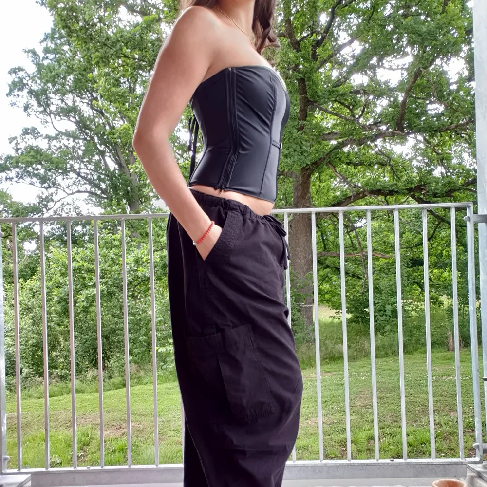 Gorgeous true vintage corset top, likely from 2000-2003 era. Black satin corset with lace-up back and minimalist rhinestone detail on the front. Hidden zipper on side. Perfect for your goth needs, I love to pair it with parachute pants for the summer. . Yläosat.