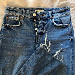 Slitna (slitna i modellen alltså) blåa högmidjade jeans från Gina Tricot. 