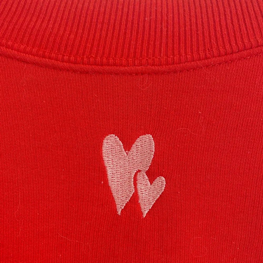 Jättefin röd sweatshirt med två broderade hjärtan på framsidan. Sparsamt använd och inga tecken på slitage. Strl S. Skriv för fler bilder!. Tröjor & Koftor.